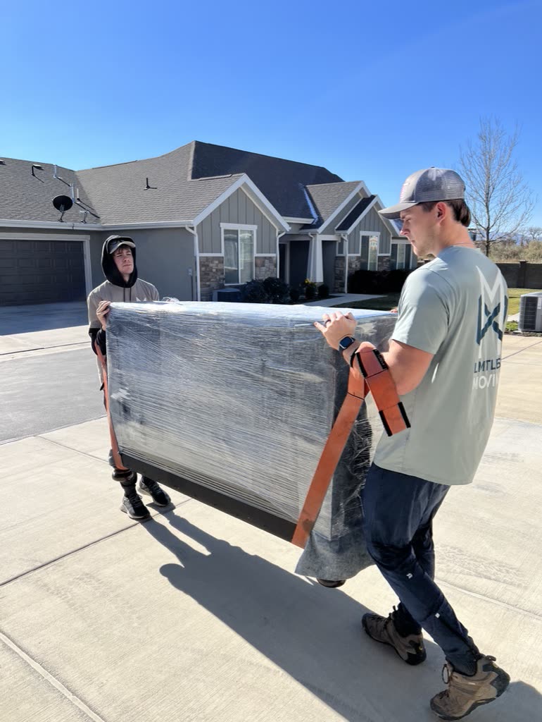Carrying a wrapped couch out to the truck
