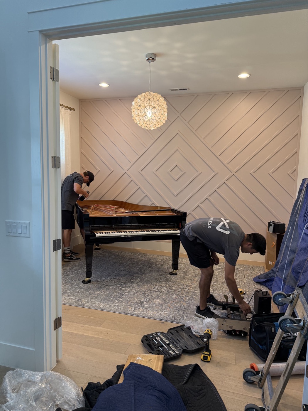 Limitless movers taking apart a grand piano in a living room