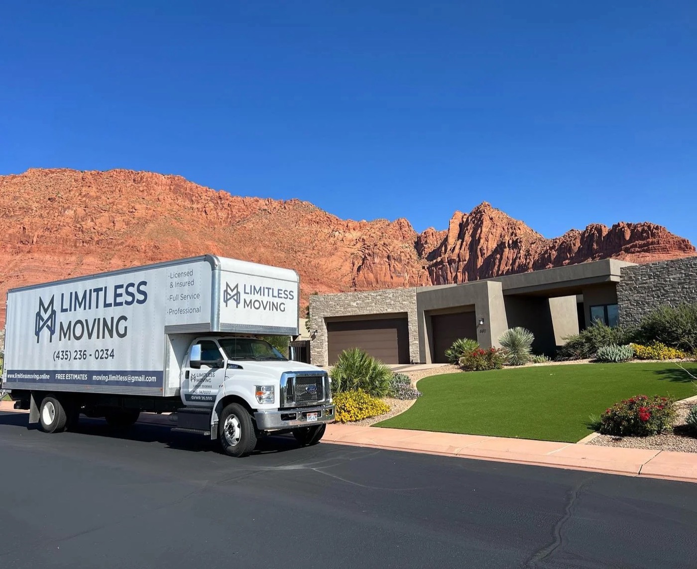 Limitless Moving truck parked below red rock cliffs